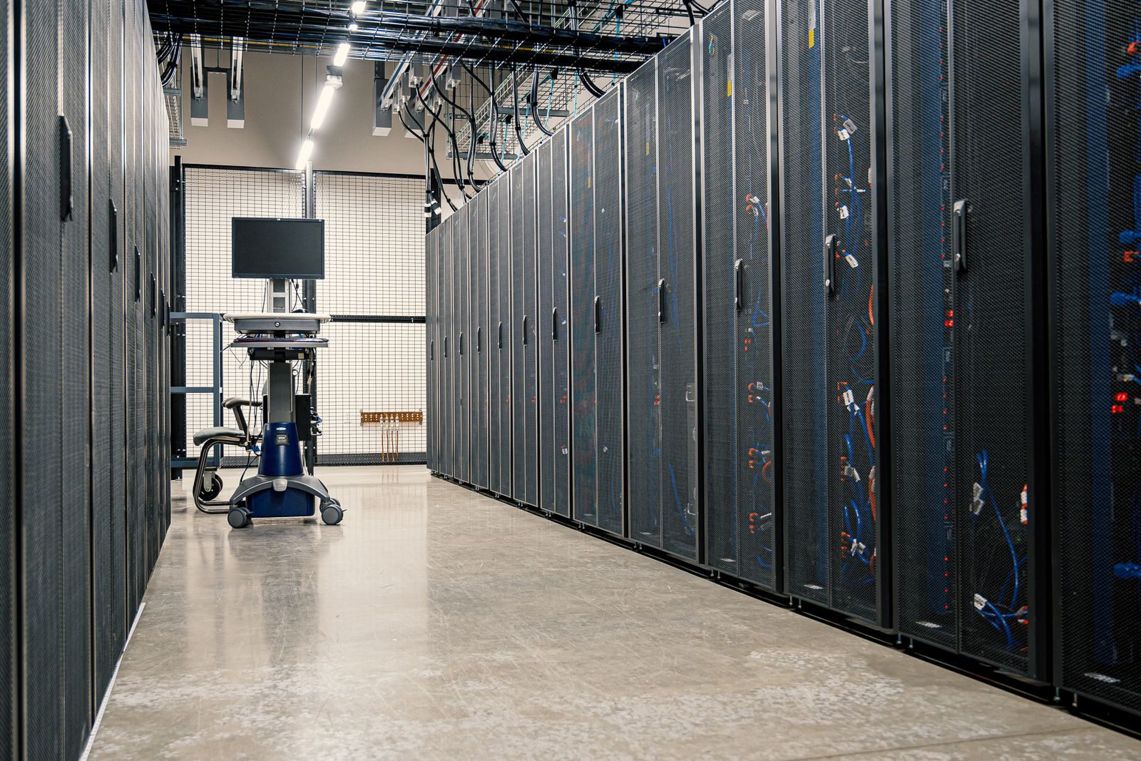 Rows of server racks with networking cables in a data center, representing isolated per-company infrastructure.