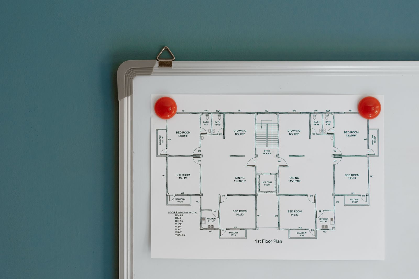 An office floor plan blueprint hanging on a whiteboard