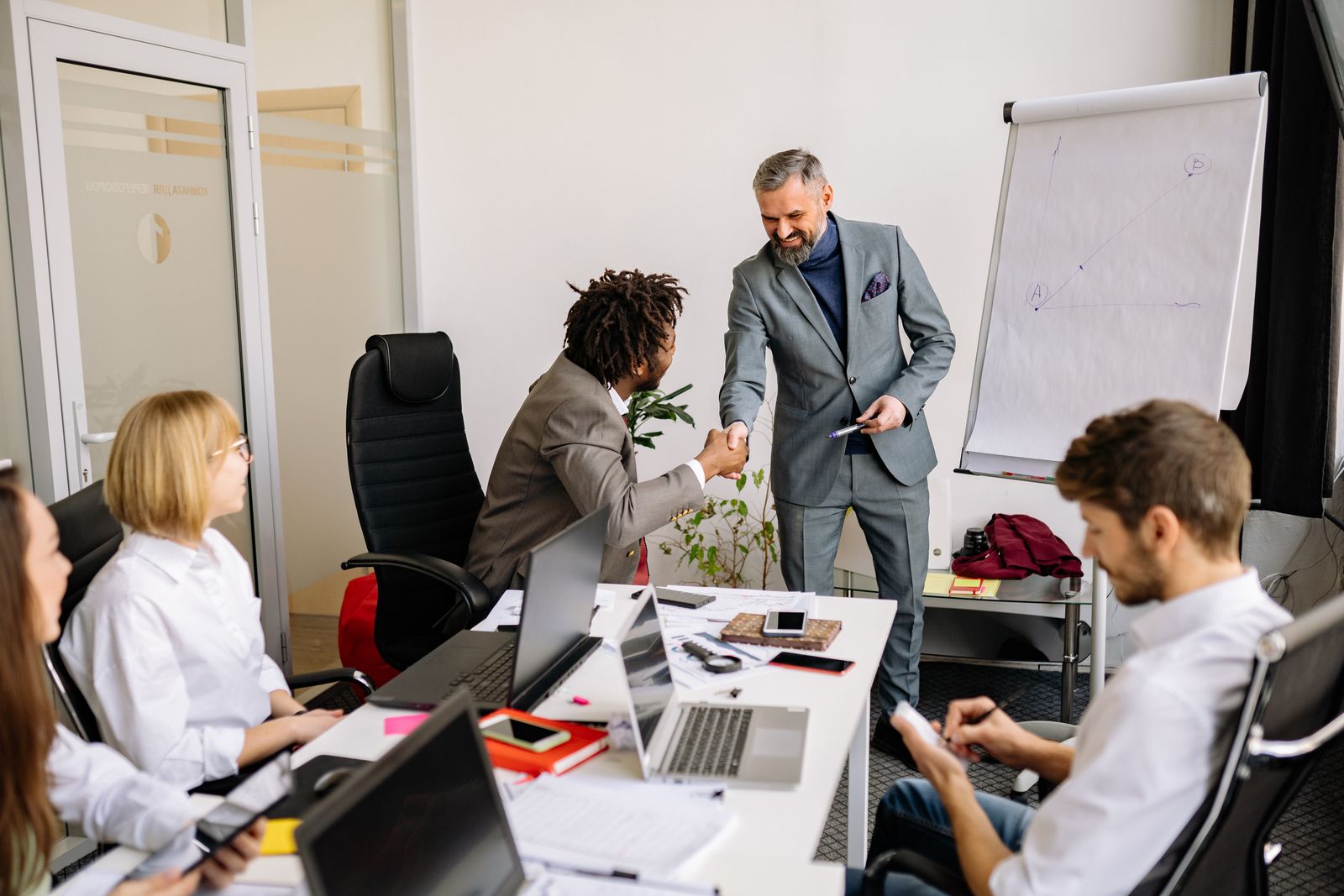 Colleagues shaking hands during a corporate meeting