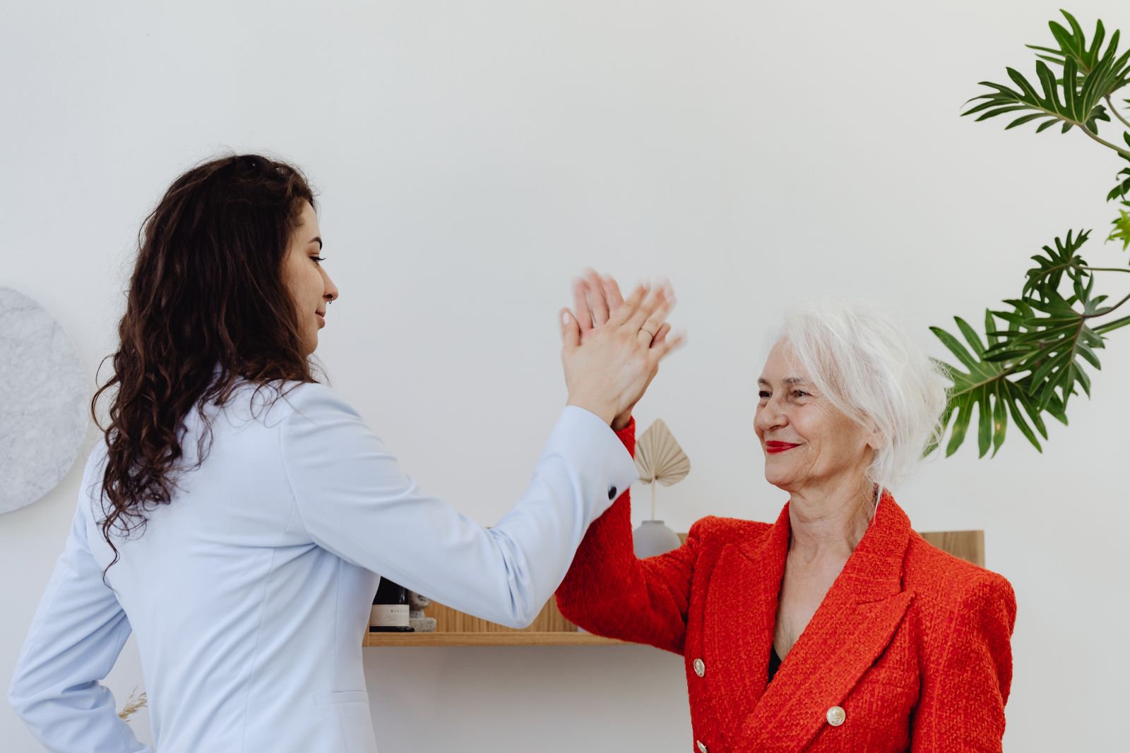 Two businesswomen sharing a high five in celebration
