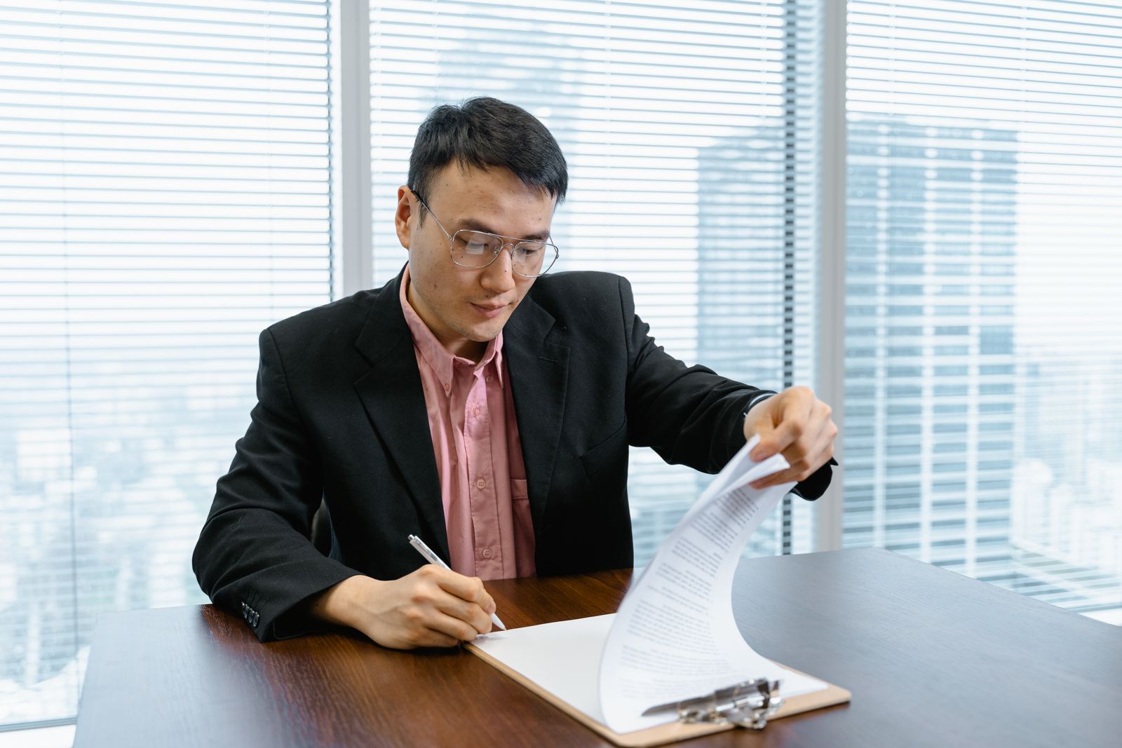 A businessman signing off on paperwork at his desk