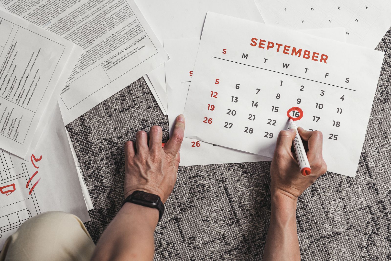 Hands holding a calendar with specific dates circled, marking planned time away.